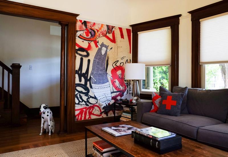 An Arts & Crafts living room in Alameda, California features a mural based on a piece of street art originally captured in Brooklyn