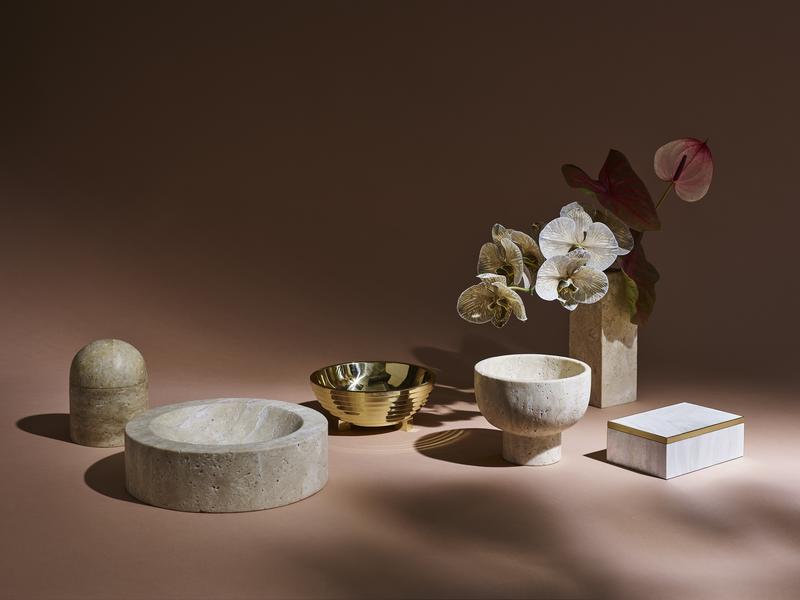 The collection comprises marble, brass, travertine, pen shell and stone