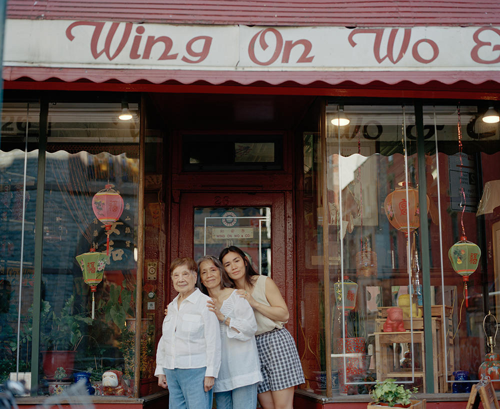 Lum with her mother and grandmother outside the shop
