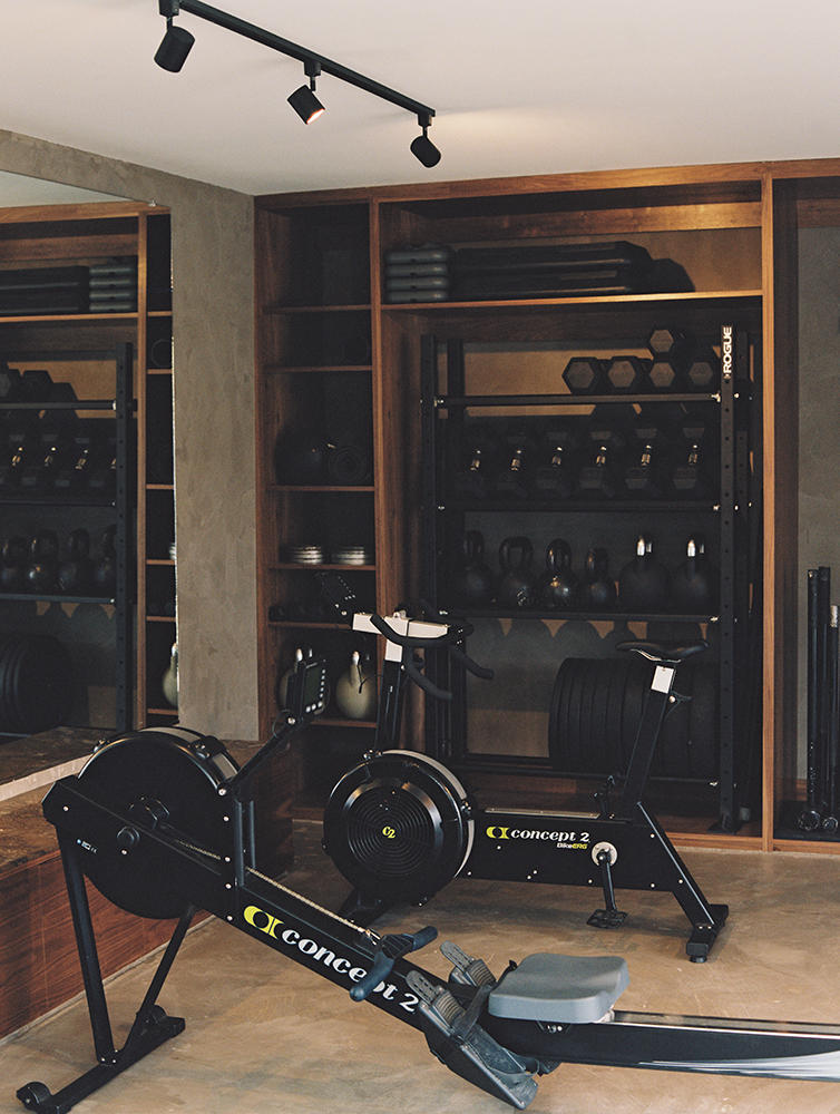 The gym Gunawan created features dark wood, polished concrete, and Venetian plaster walls.