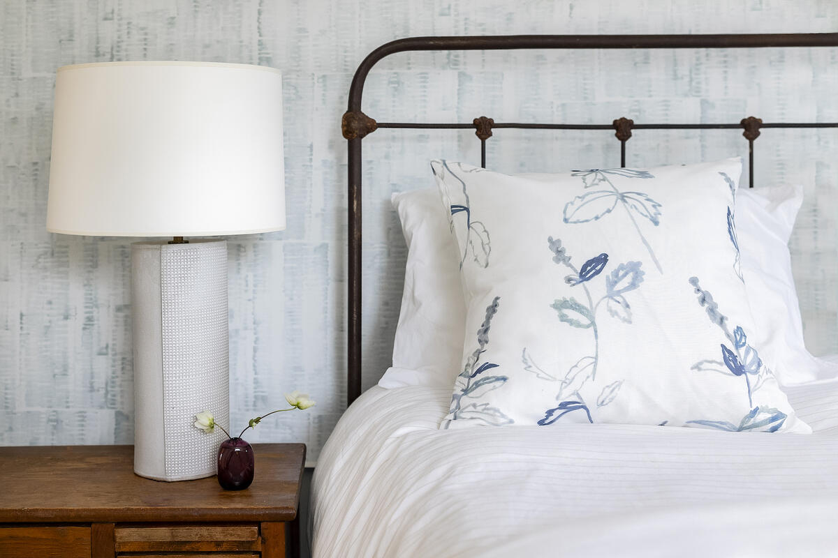 Gillian wallcovering in Mist and a pillow upholstered in Ingrid in Toodles
