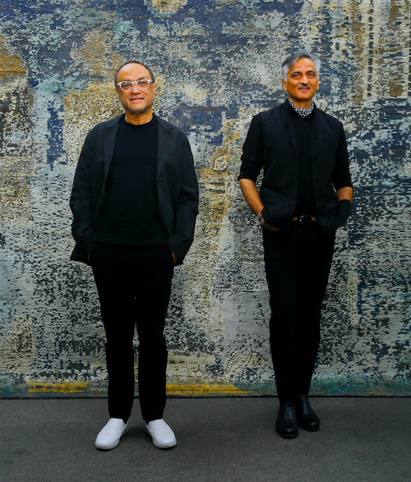 Designers David Abraham and Rakesh Thakore in front of the Sanganer carpet, inspired by the patterns on the borders of saris.