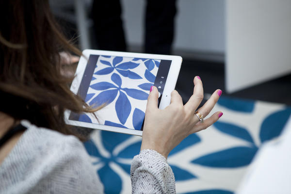A student takes a shot of one of Judy's vibrant hand-knotted rugs.