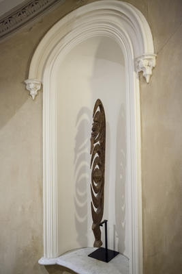 A decorative object sits in a sculpted niche in the stair hall. 