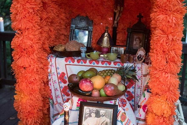 The altars are decorated with candles, buckets of flowers (wild marigolds called cempasuchil and  bright red rooster's combs) mounds of fruit, peanuts, plates of turkey mole, stacks of tortillas and big Day of the Dead breads called pan demuerto. The altar needs to have lots of food, bottles of soda, hot cocoa and water for the weary spirits.
