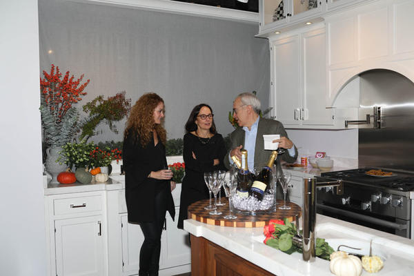 Regina Bilotta and her husband, Eric Witkin, chat with Jennifer Flanders (left) in the kitchen she styled.