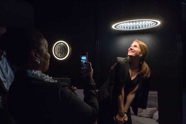 Joy Moyler snapping Sophie Donelson posing under Swarovski Lighting’s Infinite Aura collection