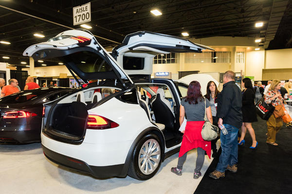 Attendees marvel at Tesla’s display.