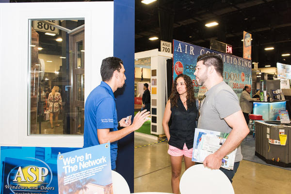 Guests visit the ASP Windows and Doors booth.