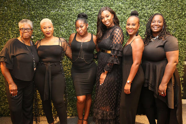 Attendees of the All Black Vignette Party pose for a photo.