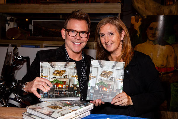Jeff Andrews poses with a guest and their copies of ‘The New Glamour: Interiors With Star Quality.’