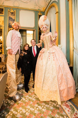 Ann Sutherland and Timothy Corrigan pose with costumed stilt walkers.