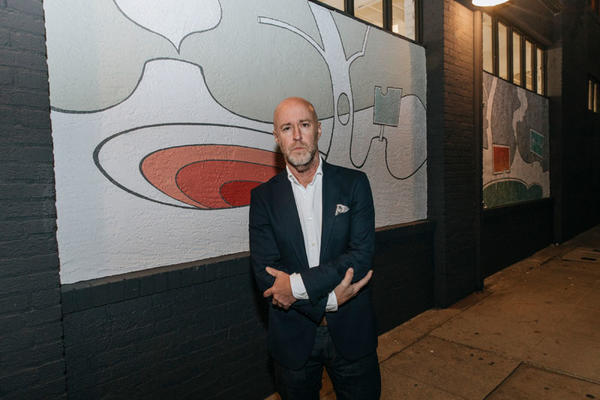 Jeff Quinn poses in front of his mural.
