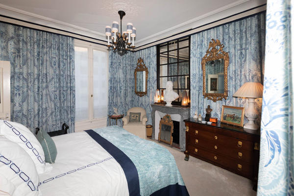 Timothy Corrigan's master bedroom features wall-to-wall blue damask drapery.