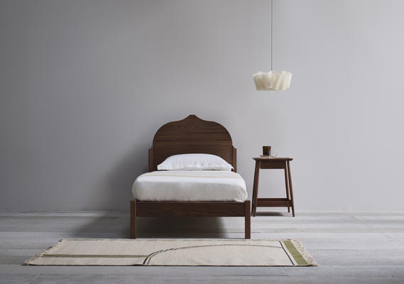 The upholstered headboard and frame follows the design’s sculptural lines.