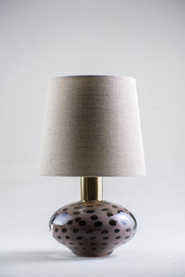 Small, attention-grabbing and cute, the Auden lamp is formed of blown glass and patinated brass. Each Auden lamp has its own character, formed by the artistry of the glass blowing technique. The lamp’s dotted surface is both playful and decorative, resembling the paintings of Yayoi Kusama. 