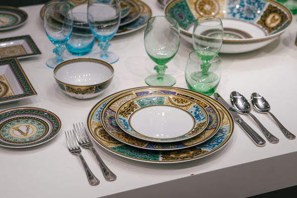 New Versace dinnerware in the Rosenthal showroom features colored glassware paired with new vibrant designs.