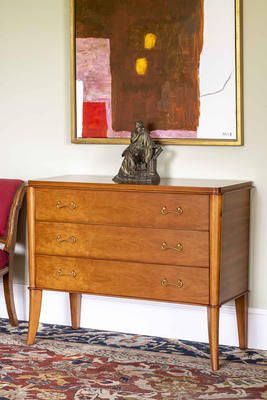 Inspired by French design of the 1940s, this chest of drawers is an elegant piece with tapered legs and curved brass handles. Based on an original antique, it has a distinctly timeless feel to it and is produced from a combination of solid beech wood legs and cherry veneer panels.