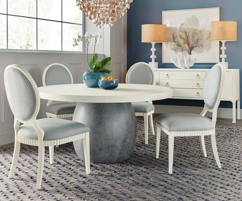 The Laguna round dining table is crafted with a unique terra cotta urn–inspired base and a top in Shell, a soft, textured, sandblasted white finish that is also featured on the Martinique side chair. The Cove Shore server is wrapped in a white-painted grasscloth, giving a visually subtle yet intriguing texture to the scheme.