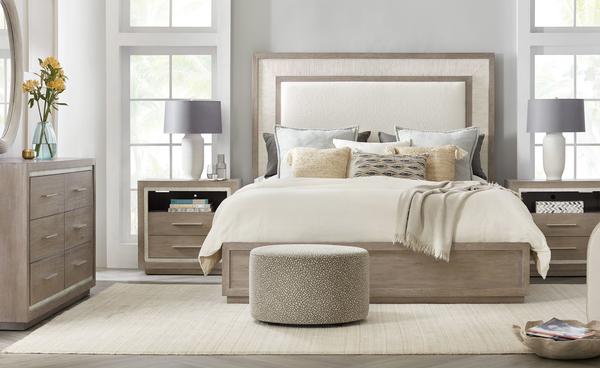 The Rookery upholstered panel bed is covered in a rich boucle fabric with a two-tone framing design and faux coral motifs. The coordinating bedroom pieces are featured in Malibu, a gray wash finish over oak veneers, with contrasting Coral borders on the face.