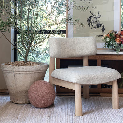 The tapered-leg Teddy accent chair alongside the Sphere pillow in Terra Cotta boucle