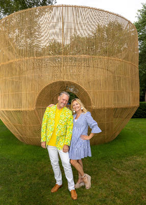Michael Cox and Donna Herman posing in front of “Fish Trap House
VII” by Cheng Tsung Feng, built on commission for LongHouse Reserve.