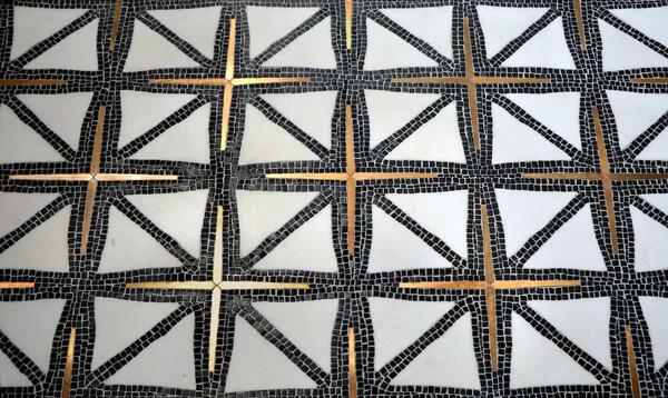 Indus, in tumbled Nero Marquina, honed Thassos and brushed Brass, is a water-jet and hand-cut mosaic from the Studio Line by New Ravenna. Designed by James Duncan.