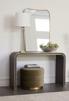 Davies console table, a versatile, modern curved design in contrasting materials. Wrapped in gray vegan leather with the edges trimmed in brass, sealed to slow aging.