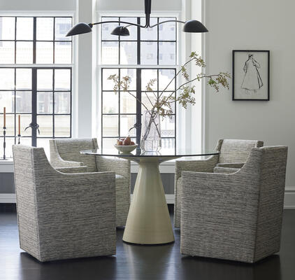 Edie dining chairs, now offered fully upholstered and on casters for ease of movement. Customizable in fabric or leather. Featured here in Quito-Smoke, a Kravet fabric. 