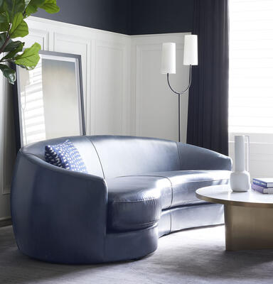 From the curved Giselle collection, the Giselle sofa, featured in Mont Blanc Blue Smoke leather. Also customizable in fabric.