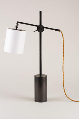Clean lines and a cylindrical base give the Farnham desk lamp its modernist bona fides. The arm, with visible joint, can be angled in various positions. Shown in brass.