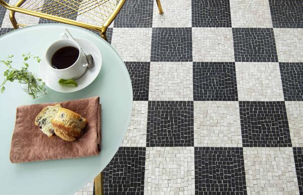 Roman Check, a hand-chopped stone mosaic shown in tumbled Nero Marquina and Whitewood, is part of the Heritage collection by New Ravenna.