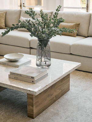 Close-up of the Telluride coffee table, a simple modern design in rich natural materials: Omani marble with textural hammered edges and sustainable FSC-certified Grade A solid teak.