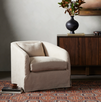 Curved arms and a machine-washable Belgian linen slipcover give the Topanga slipcover swivel chair a laid-back look.
