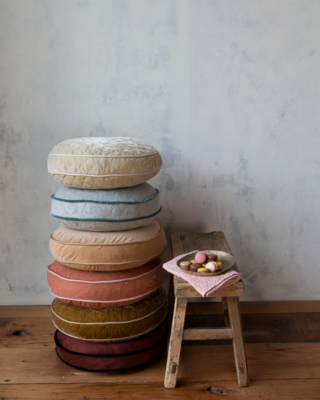 Stack of 18-inch-diameter round pillows in multiple colors and fabric collections
