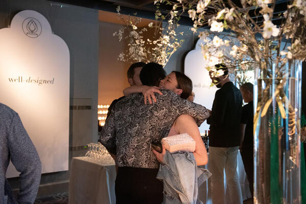 Well-Designed co-founders Caleb Anderson and DeAndre DeVane share a hug with Benjamin Moore’s Lauren Corbin