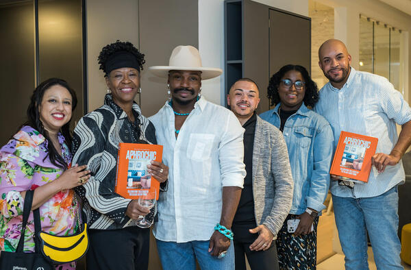 John Goodman (center) and guests pose with their copies of “AphroChic: Celebrating the Legacy of the Black Family Home,” in which Goodman’s home is featured