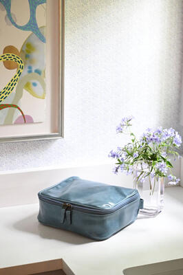 A dop kit from Moore & Giles and Anyon Atelier vase in a powder room featuring wallpaper from Lea Rutledge