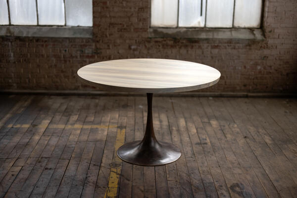 Our midcentury modern–inspired Amicalola pedestal base is hand-cast by Alabama artisans. Here, it’s paired in cast bronze with our round Gulf Sand tabletop to create a rustic yet sleek dining table.