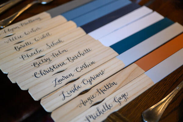 Monogrammed paint stir sticks by Karly Kassay Calligraphy adorned the table setting as custom place cards 