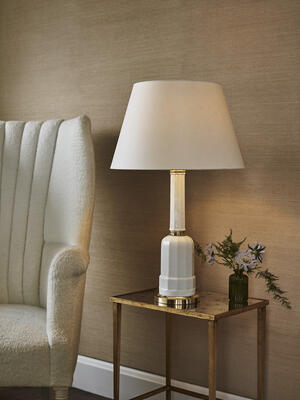 The Colmar table lamp is inspired by a French oil lamp, its multifaceted white glass form finished with an elegant cast-brass base and capital