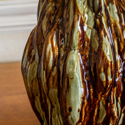 The Ditcham table lamp is defined by its semitranslucent brown-and-green glaze, which cascades down its sculptural form 