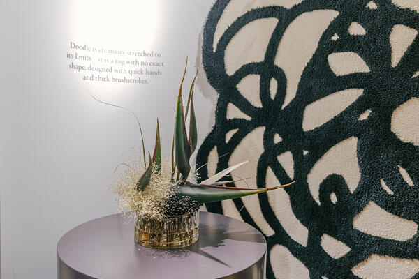 A Doodle rug by Paola Navone provides a graphic backdrop for strikingly exotic arrangements by FDK Florals