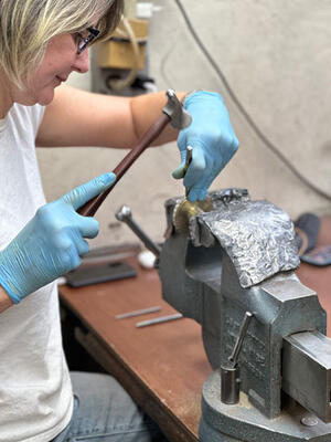 A P.E. Guerin artisan demonstrates how to hammer a border around a knob