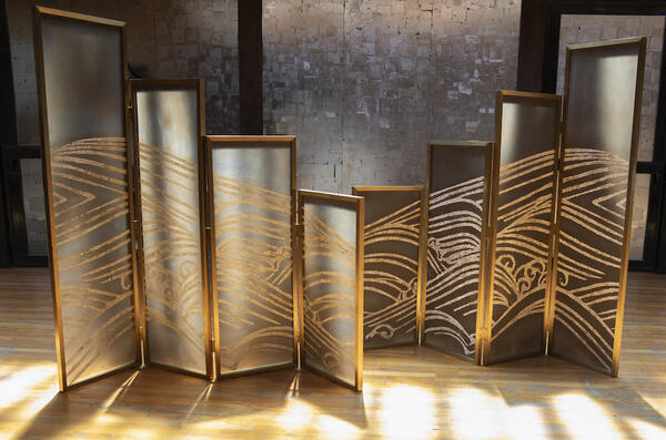 Olas screens: Mimicking the swells of wild ocean waves, the organic materiality and fluid patterning of the eggshell mosaic is only contained by  the sturdy brass framework—a striking juxtaposition that balances structure and movement 