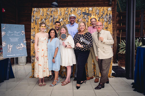 The team from Kravet posing in front of a starry Celeste print fabricated as drapery by The Shade Store
