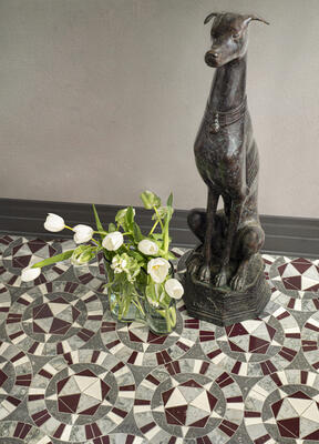 Giacomo, a waterjet-cut mosaic, shown in honed Basalto Orvieto, polished Bianco Antico, Snapdragon and Oyster