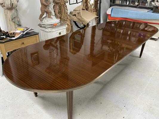 The ribbon-stripe mahogany surface of the Canabas dining table