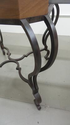 Leg and stretcher detail of the Louis XV–style steel-base table
