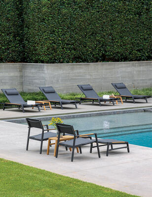 Summit aluminum chaises in Charcoal with cushions, Summit lounge chairs and Summit teak side tables